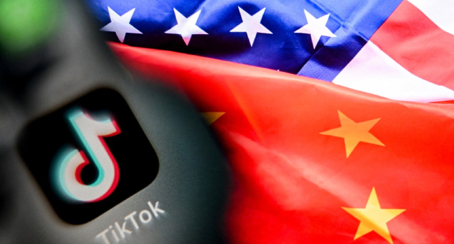 Tiktoks Logo On A Smartphone Screen L And Us And China Flags Combo Illustration On A Laptop Screen