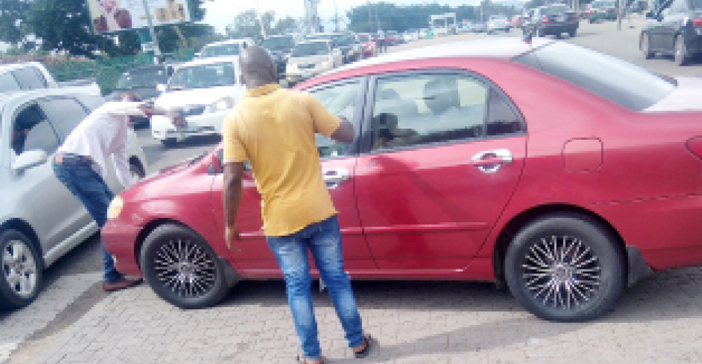 Touts Trying To Arrest A Car For Flouting Traffic Rule At Wuse Market