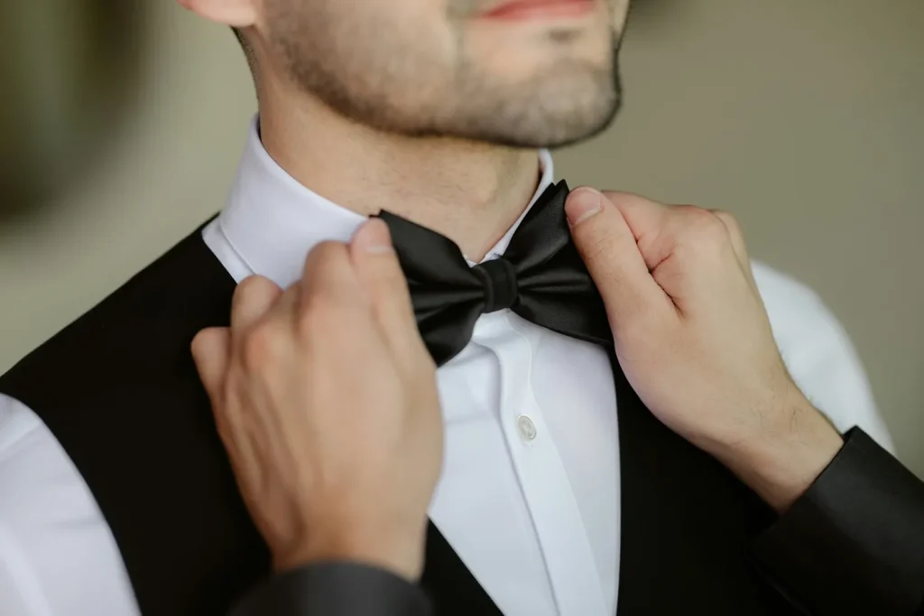 A Man With His Bowtie Getting Adjusted