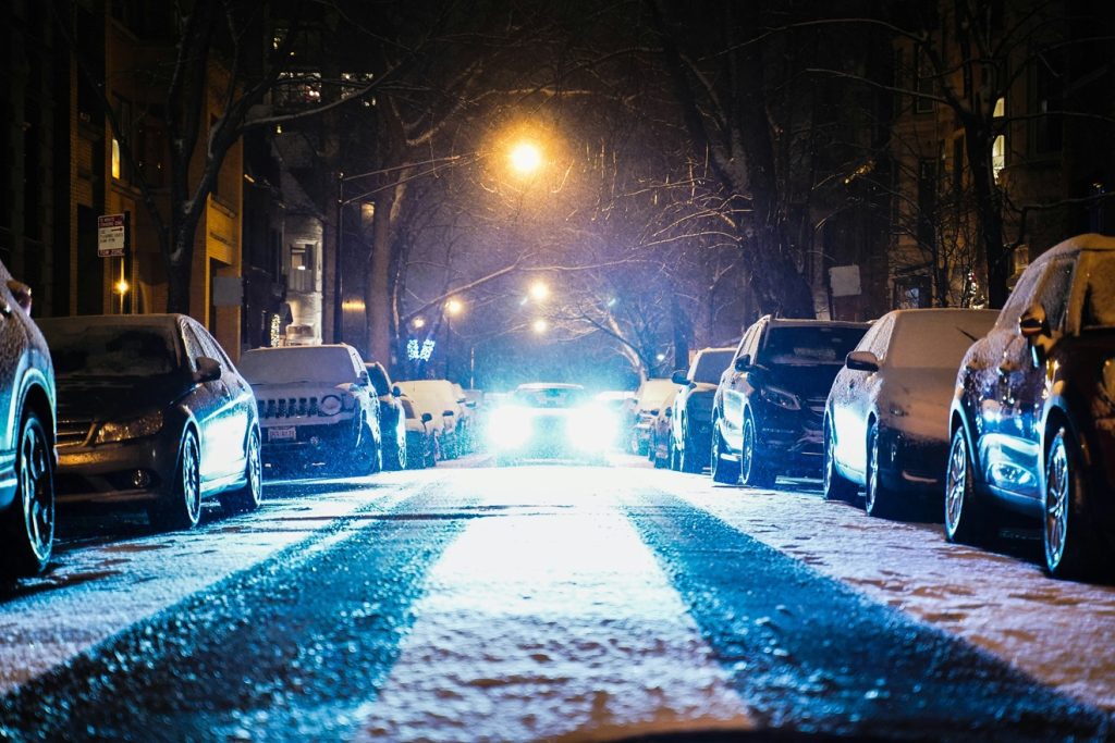 Cars Parked On Both Sides Of The Road With One Moving In The Middle