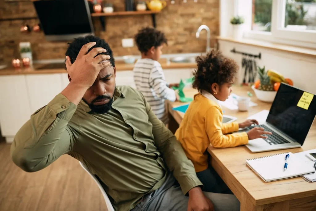 Working African American Father Feeling Frustrated While Working Home