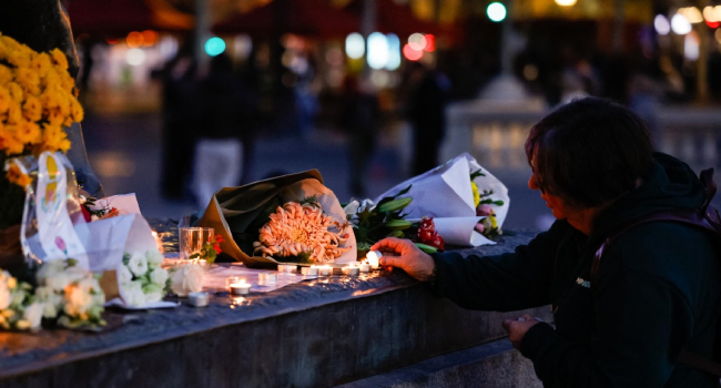 A Woman Lights Up A Candle At A Makeshift Memorial In Tribute Of The Victims Of Paris Attacks