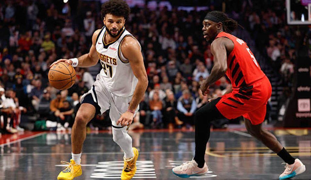 Portland Oregon Jamal Murray Of The Denver Nuggets Dribbles The Ball Against Jrue Holiday Of